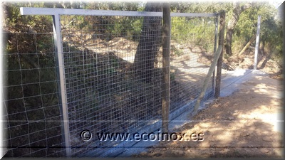 Instal·lació de malla anudada i porta corredissa.