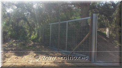 Instal·lació de malla anudada i porta corredissa.